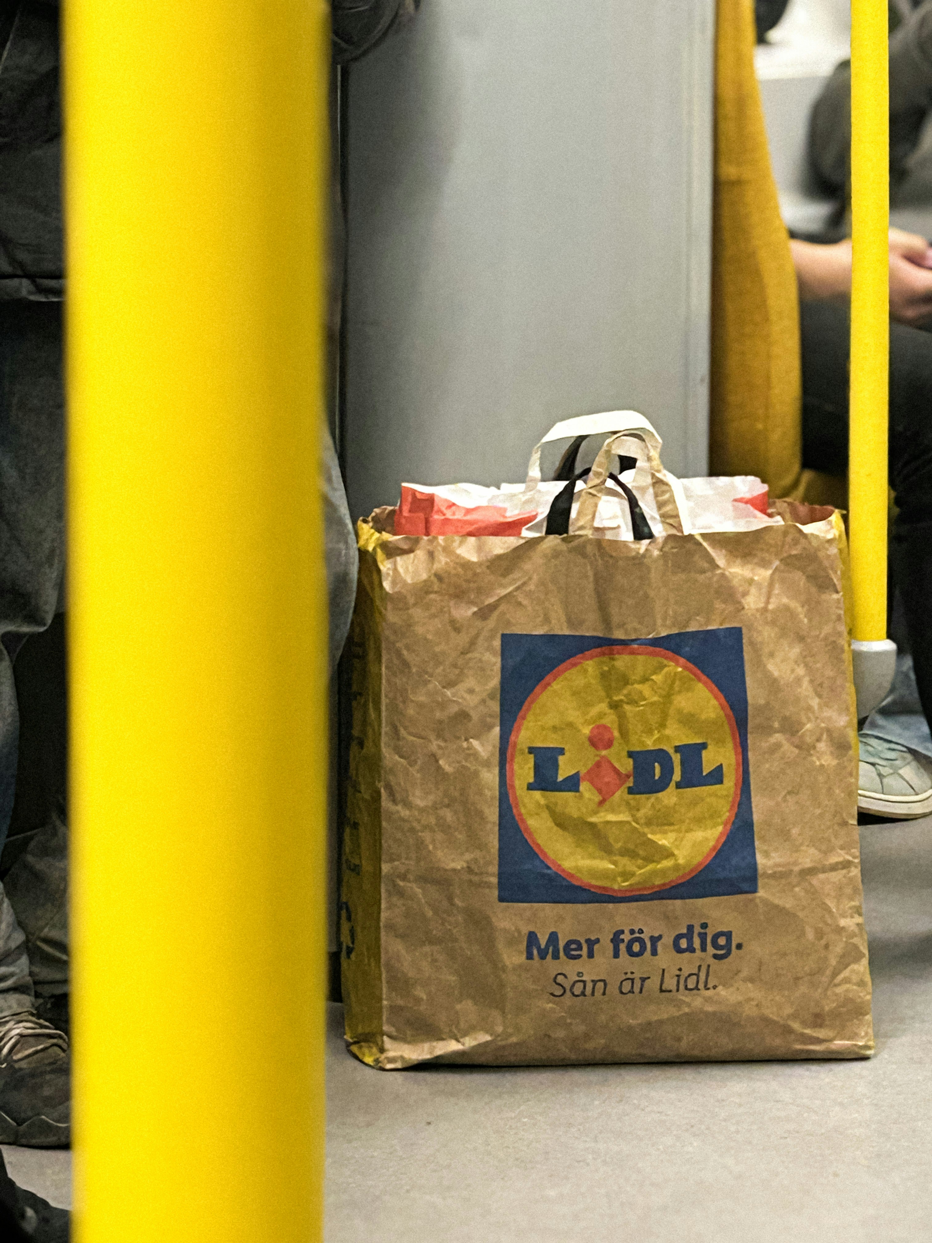 Brown paper shopping bag with lidl logo on train