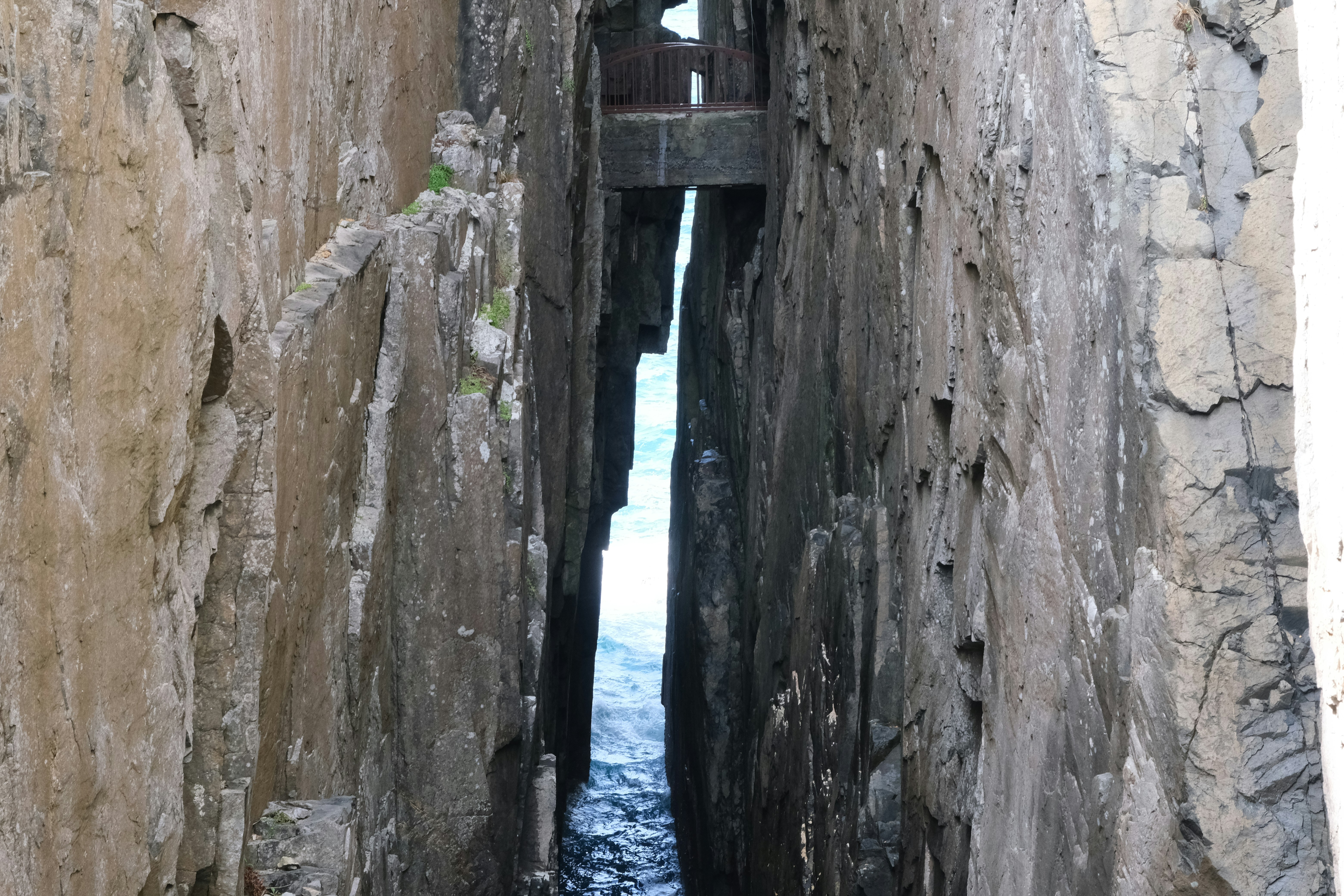 Narrow passage between rocky cliffs overlooking the ocean