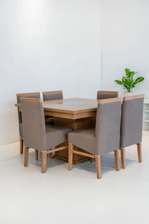 Dining table with six upholstered chairs in a bright room.