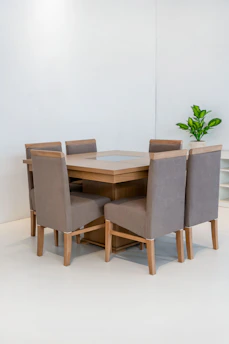 Dining table with six upholstered chairs in a bright room