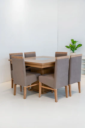 Dining table with six upholstered chairs in a bright room.