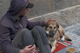 Man petting a dog sitting on a mat