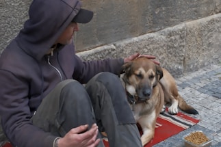Man petting a dog sitting on a mat