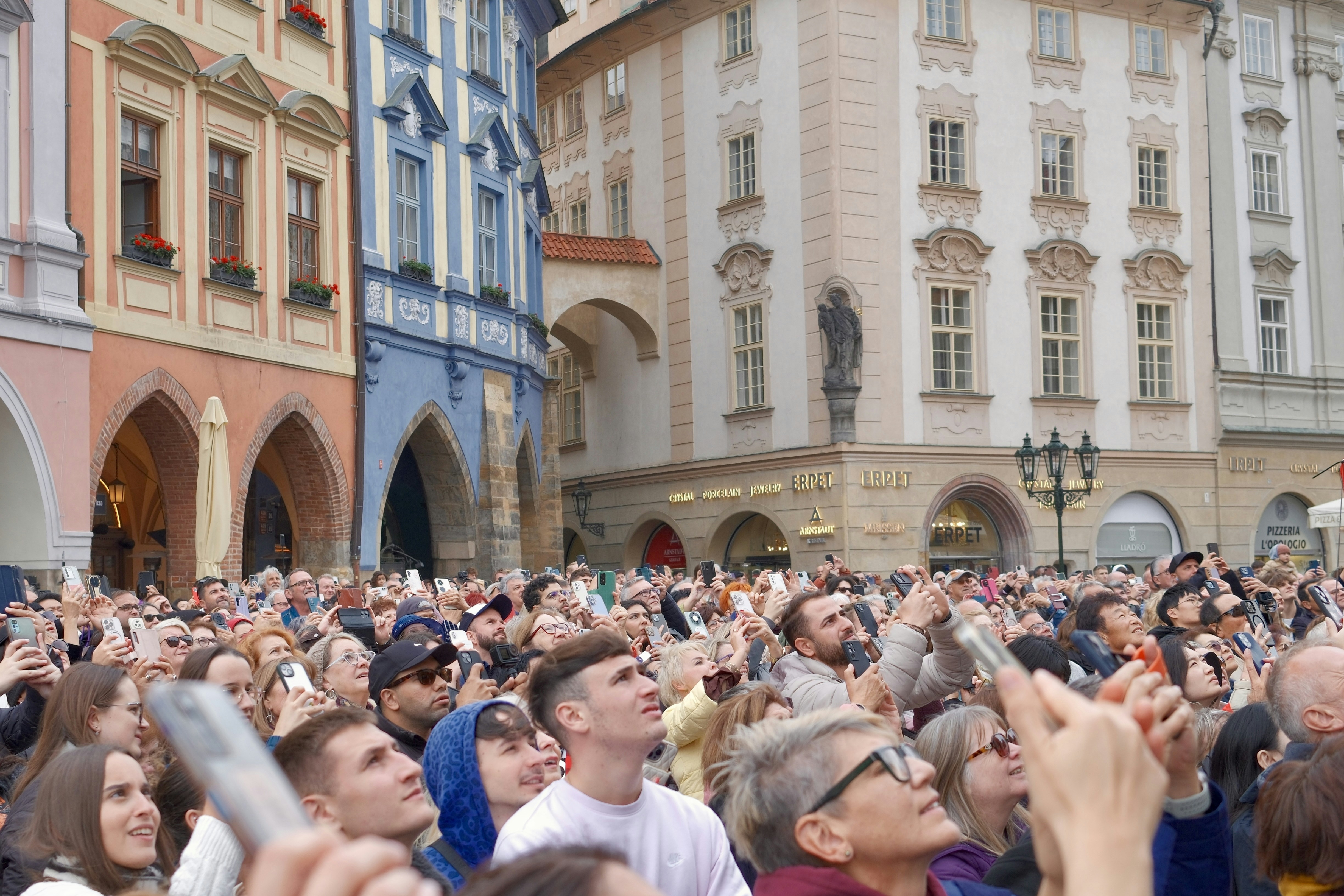 Multitud mirando hacia los edificios en una plaza europea