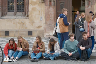 Group of young people sitting outside a building