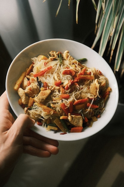Chicken stir-fry with noodles and vegetables in a bowl