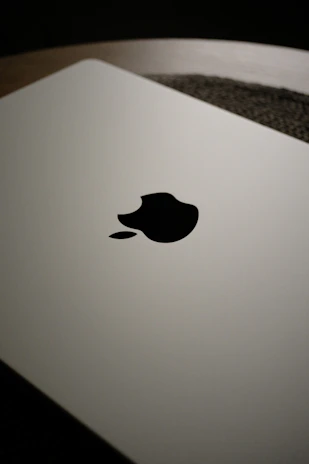 Close-up of a closed white laptop with apple logo.
