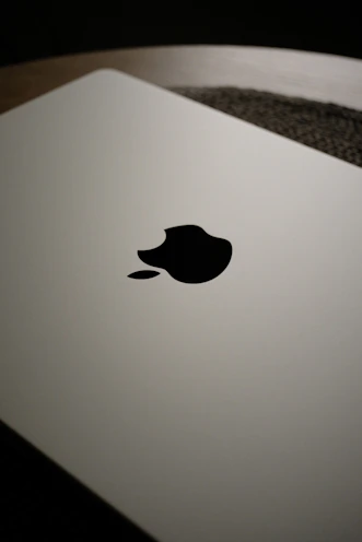Close-up of a closed white laptop with apple logo.