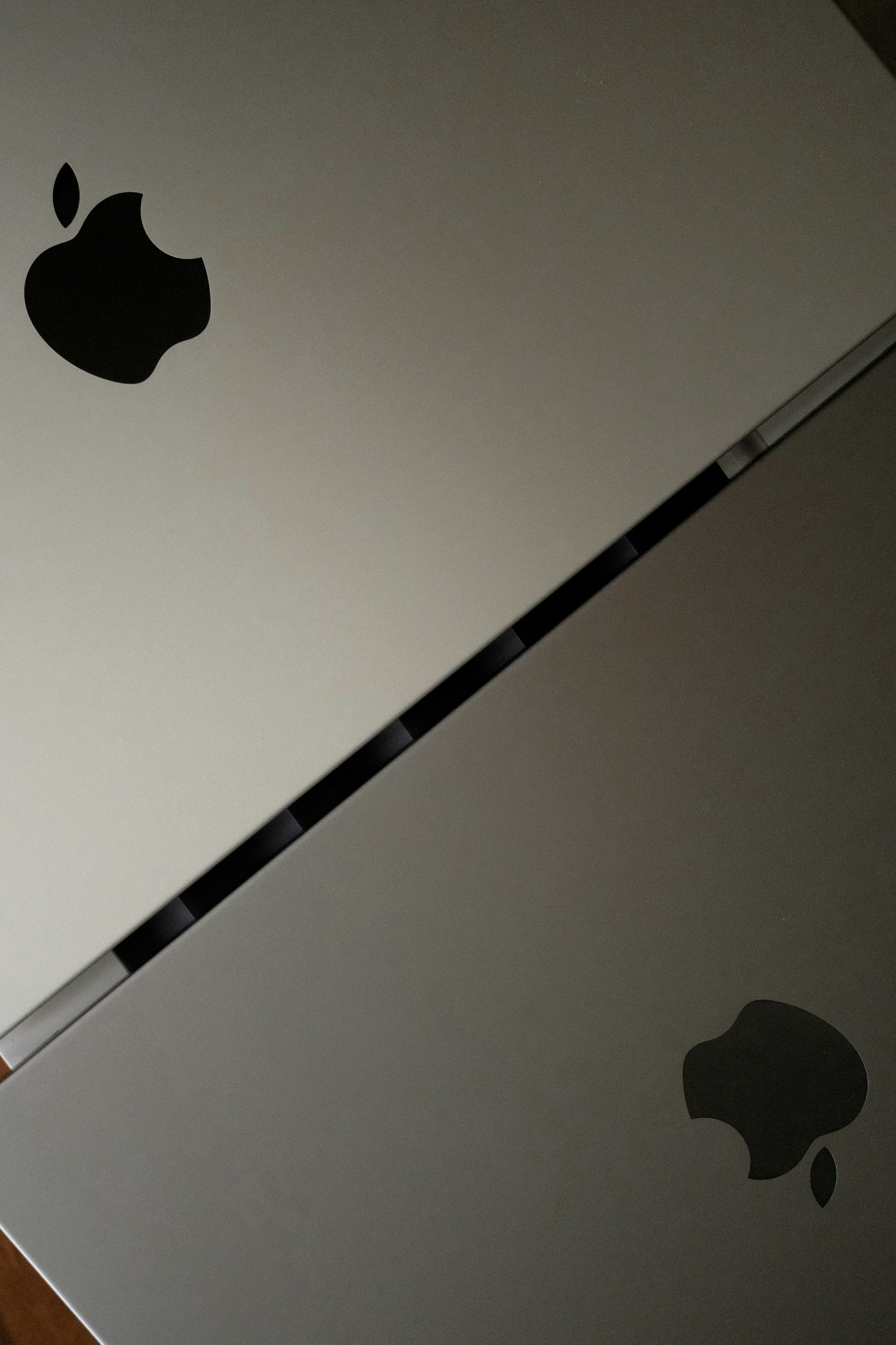 Two Apple laptops with visible logos