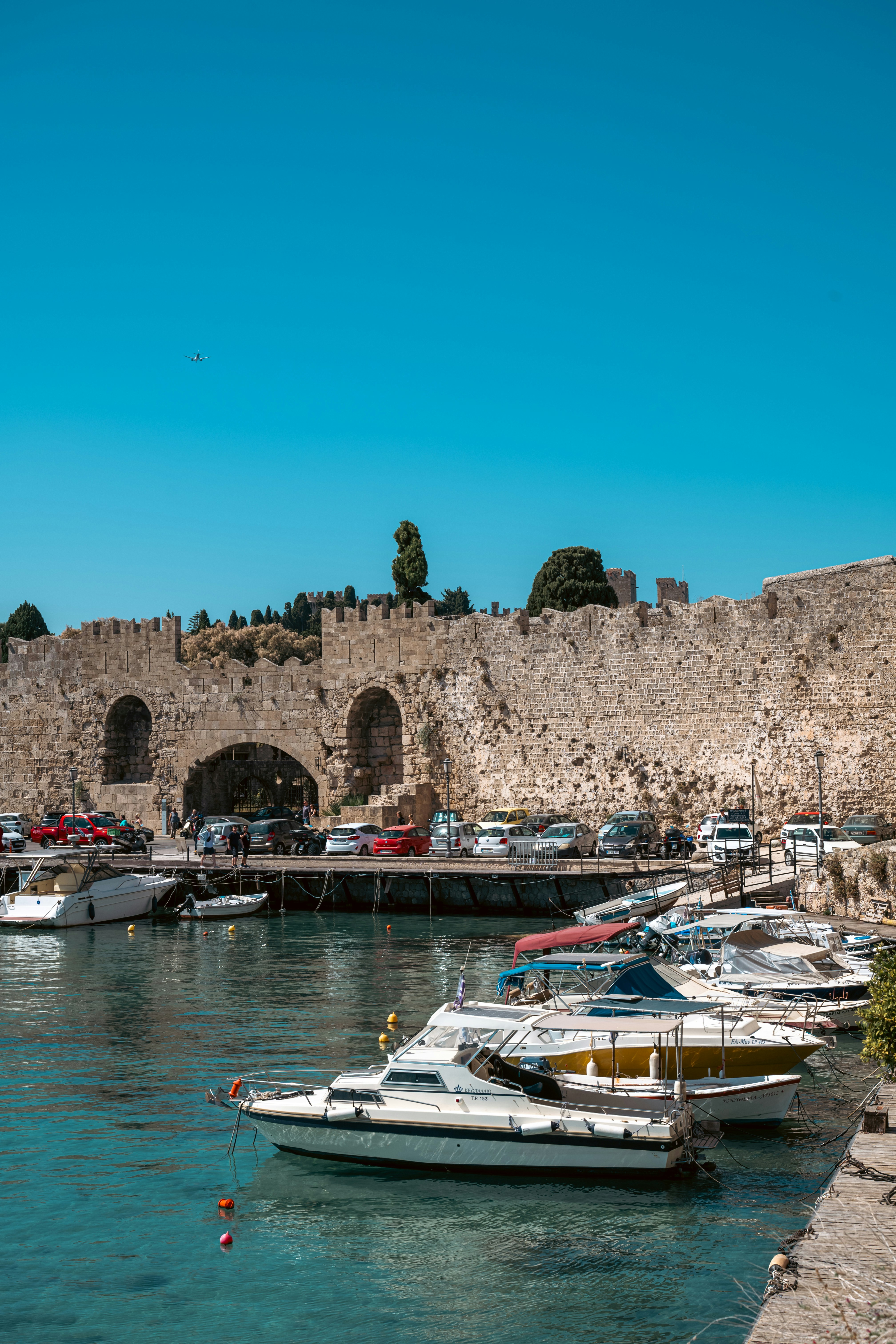 Boats docked at a harbor with medieval stone walls.