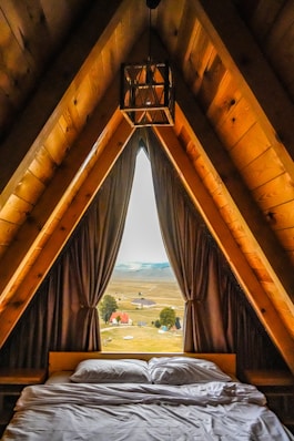 Cozy a-frame cabin bedroom with a scenic landscape view.