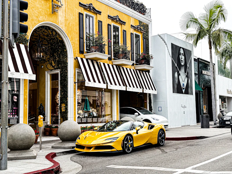 Gelber Sportwagen vor gelbem Gebäude