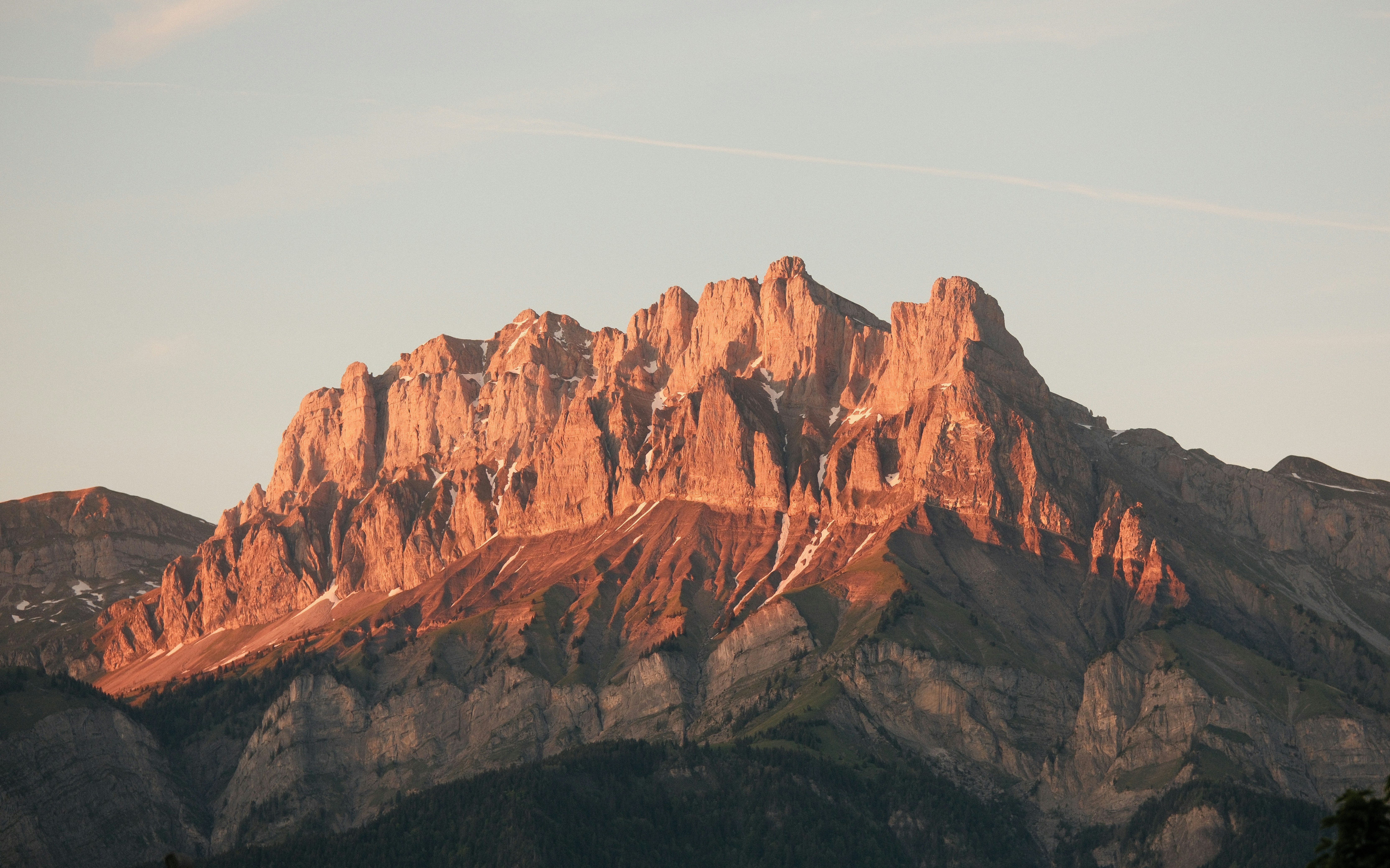 Pic montagneux déchiqueté illuminé par la lumière du soleil de l’heure dorée.