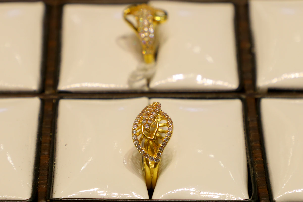 Two ornate gold rings with diamonds displayed on a jewellery tray