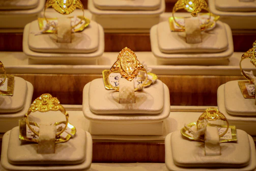 Rows of ornate gold rings displayed on stands.
