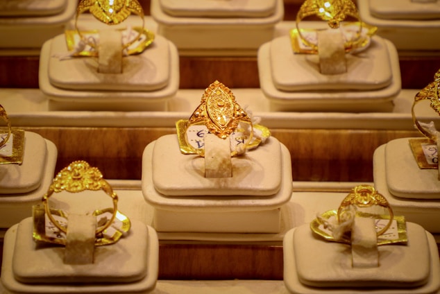 Rows of ornate gold rings displayed on stands.