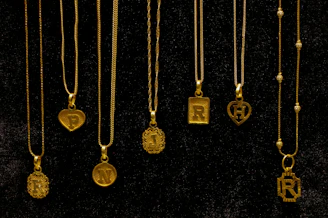 Several gold necklaces with initial pendants displayed.