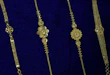 Four delicate gold bracelets on blue velvet