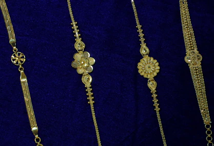 Four delicate gold bracelets on blue velvet