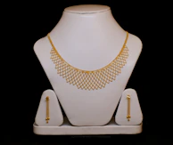 Gold necklace and matching earrings on display.