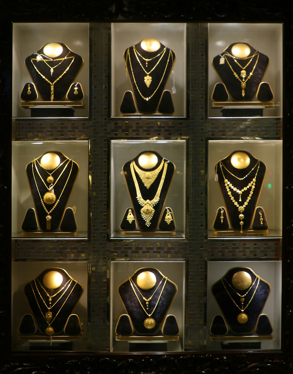 Collection of gold necklaces displayed in a store.