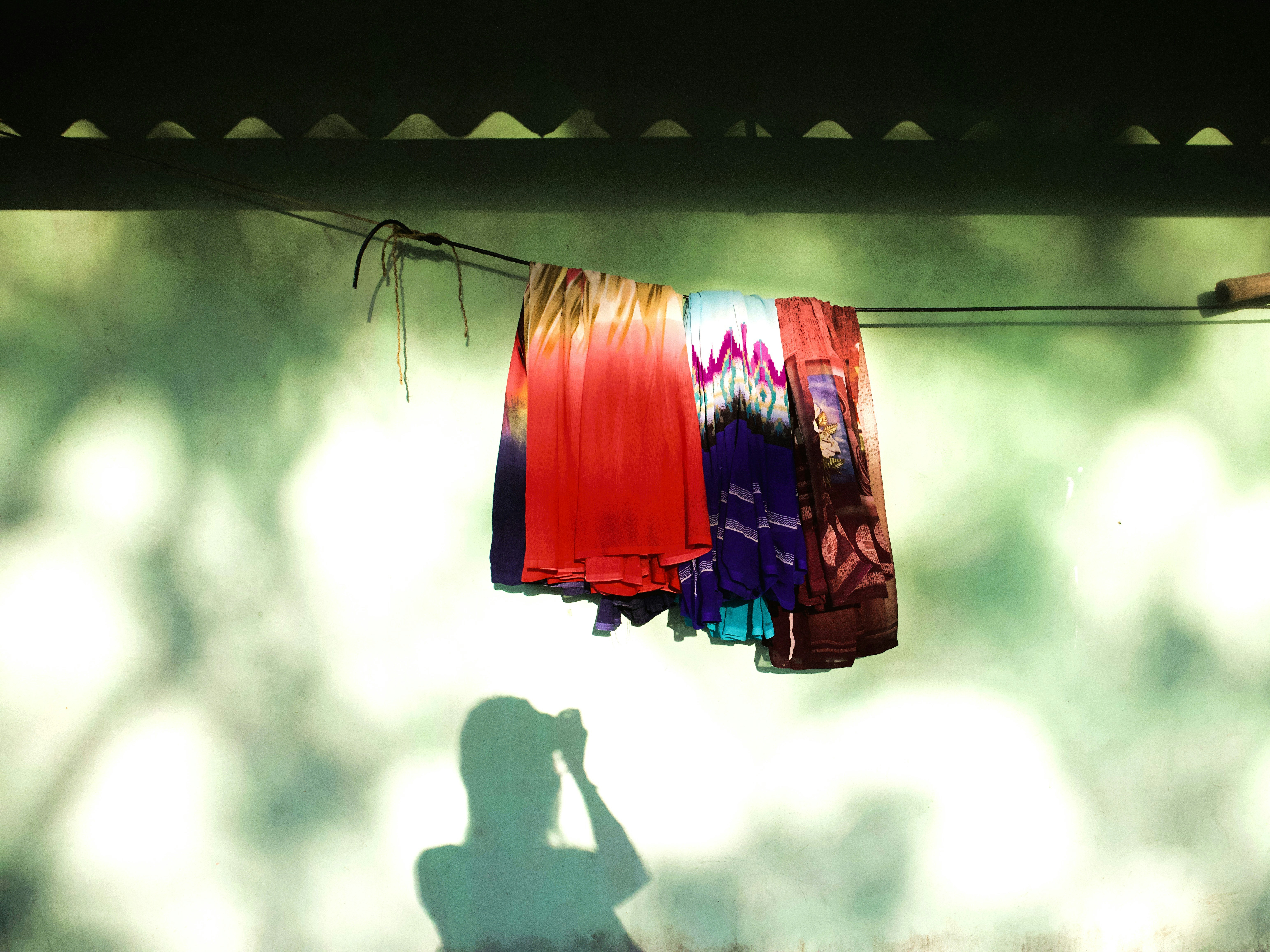 Colorful clothes hanging on a line with shadows.