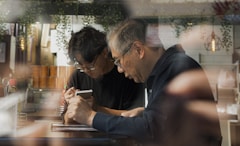 Two men looking down at a small object together