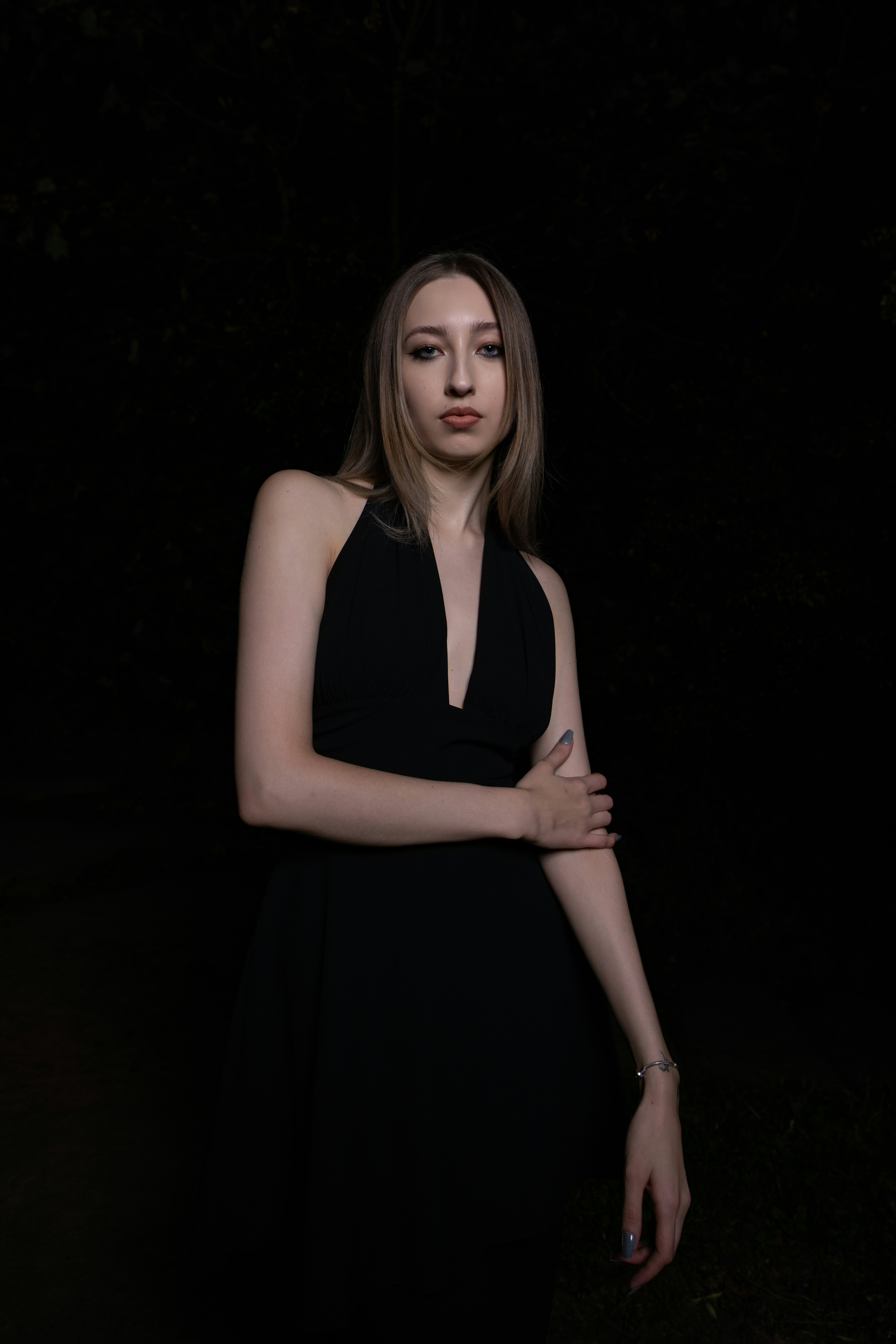 A woman in a black dress at night