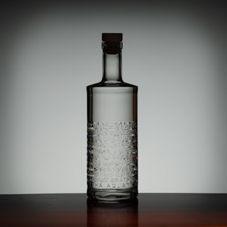 Clear glass bottle with cork and ice