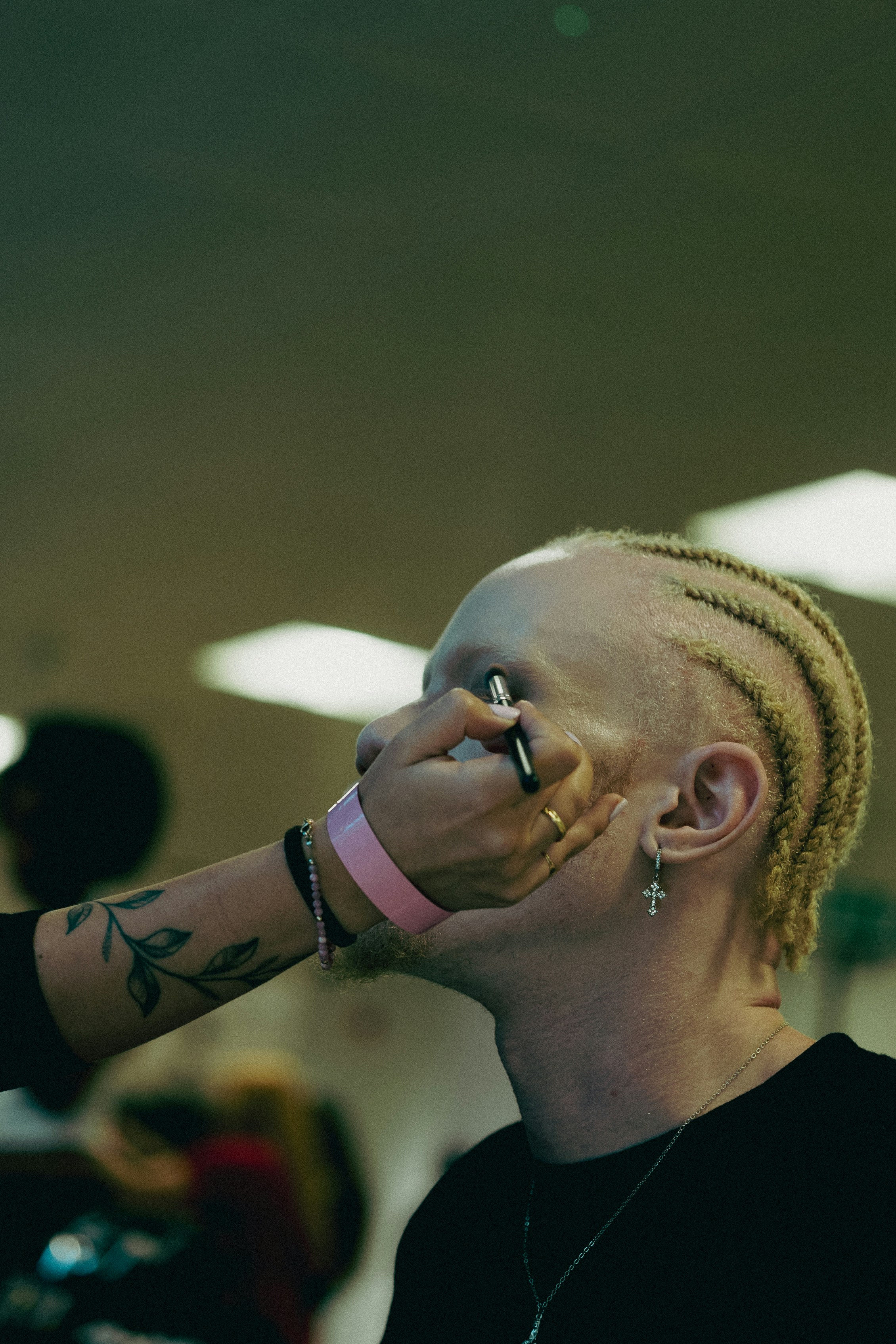 Makeup artist applying eyeliner to a person's eye.