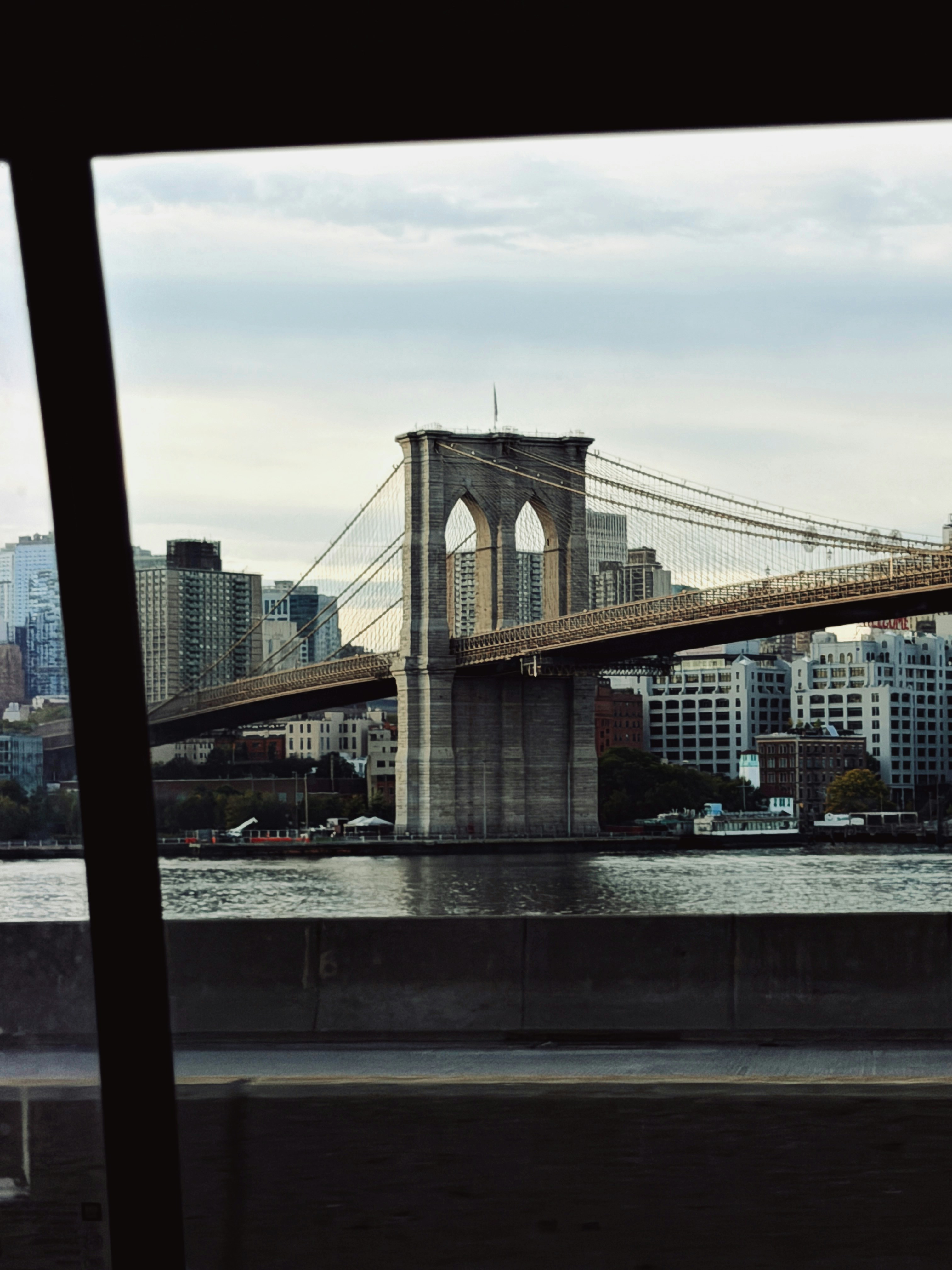 Brooklyn bridge with city skyline under cloudy sky