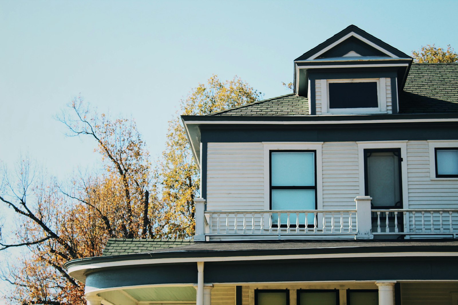 Second story and dormer windows on a white two story home above a porch roof, typical exterior window cleaning work for Cincinnati East Window & Gutter Cleaning