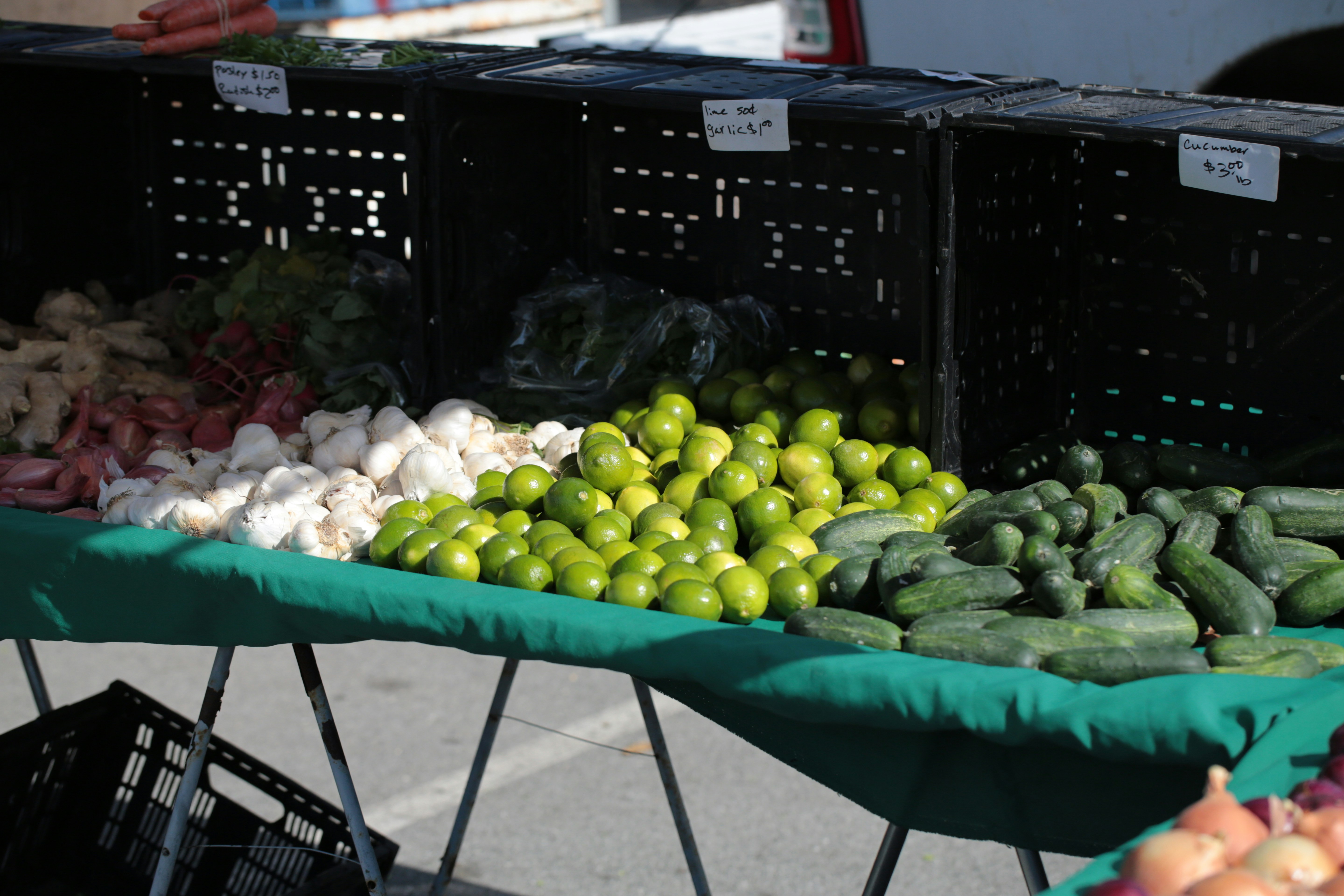 Fresh produce including limes, garlic, and cucumbers at market.
