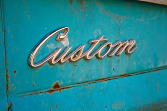 Chrome emblem on rusty teal surface