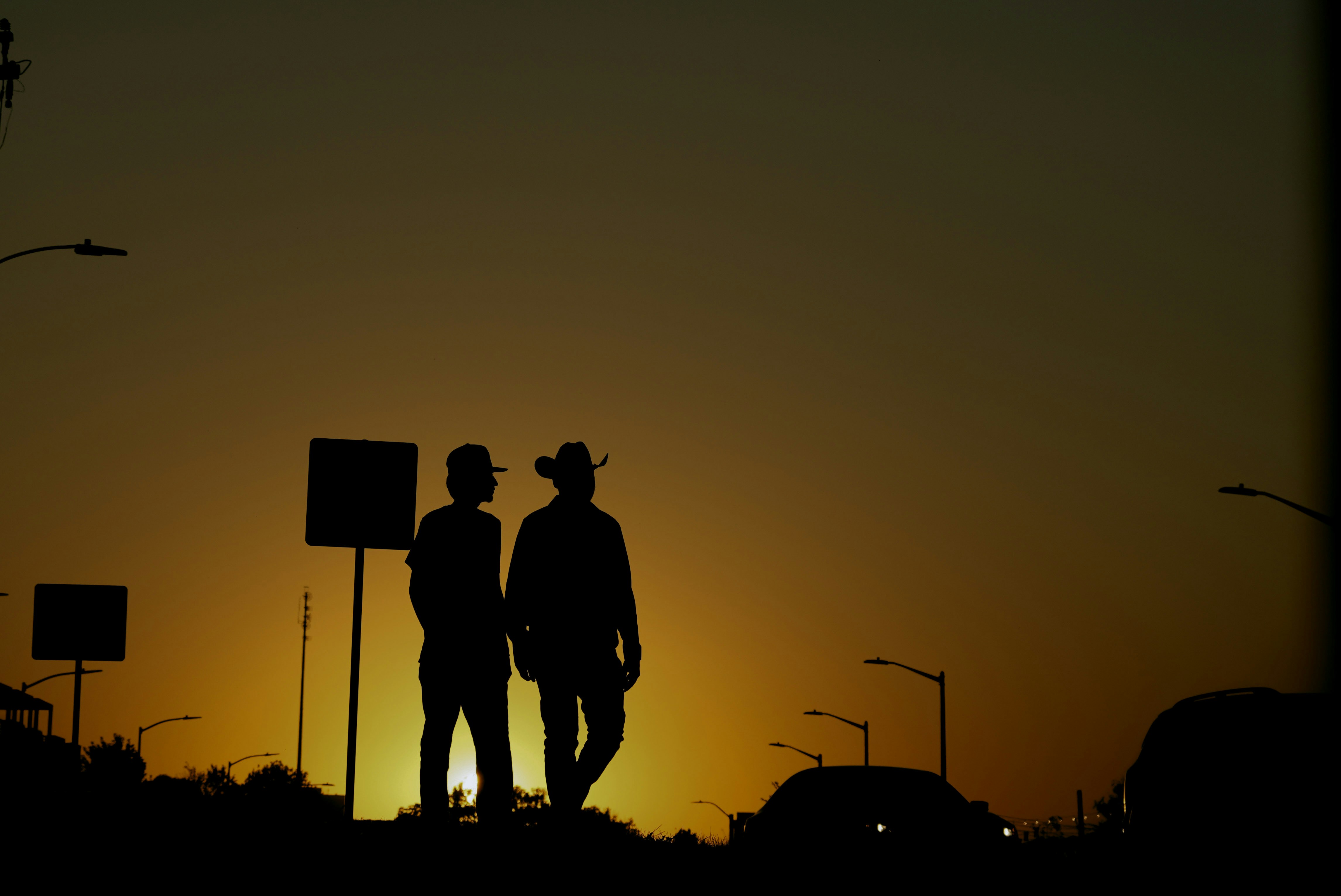 鮮やかな夕焼けの空を背景に2人が歩きます。