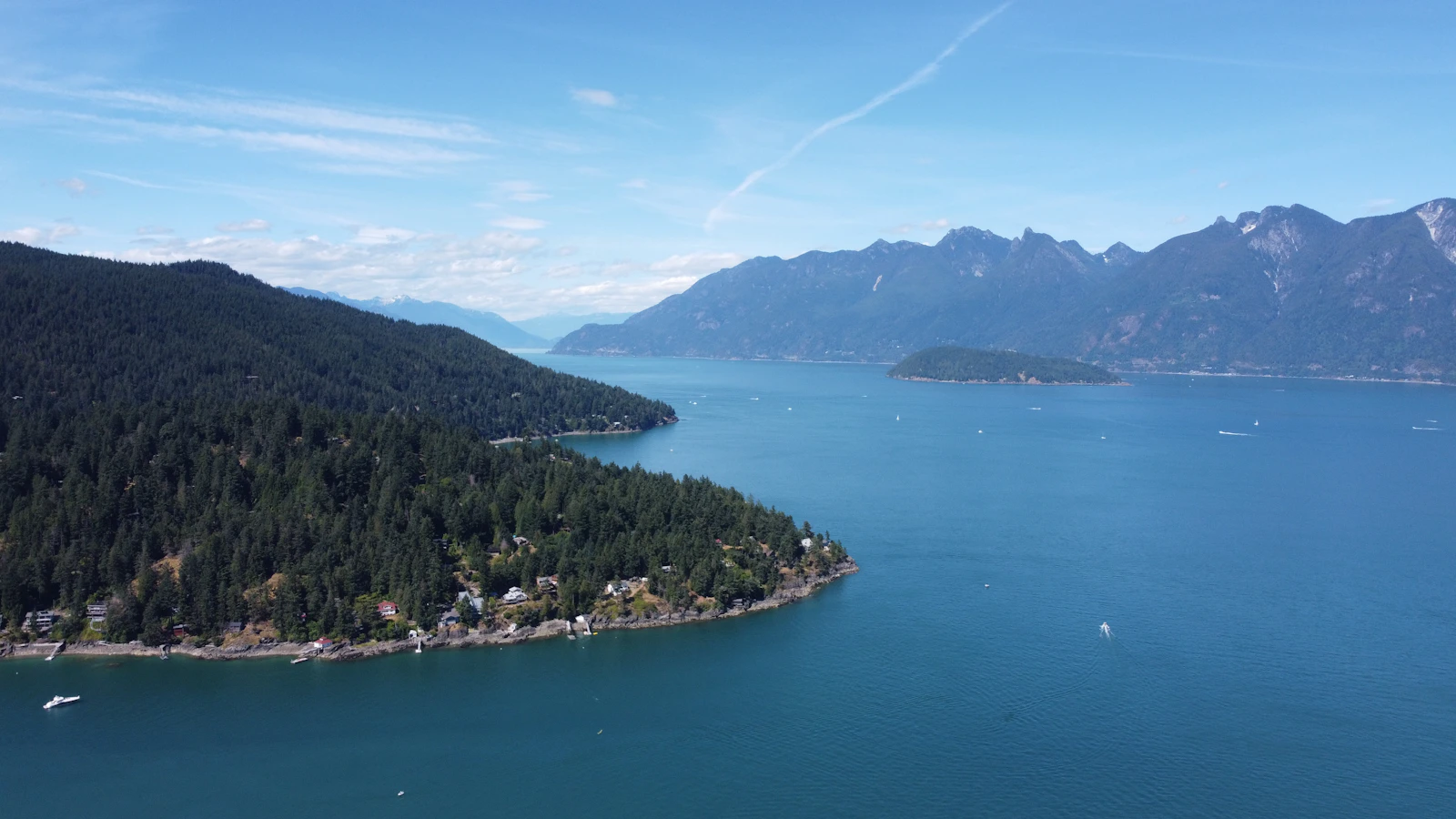 Forested Bowen Island and blue coastal waters beneath British Columbia mountains