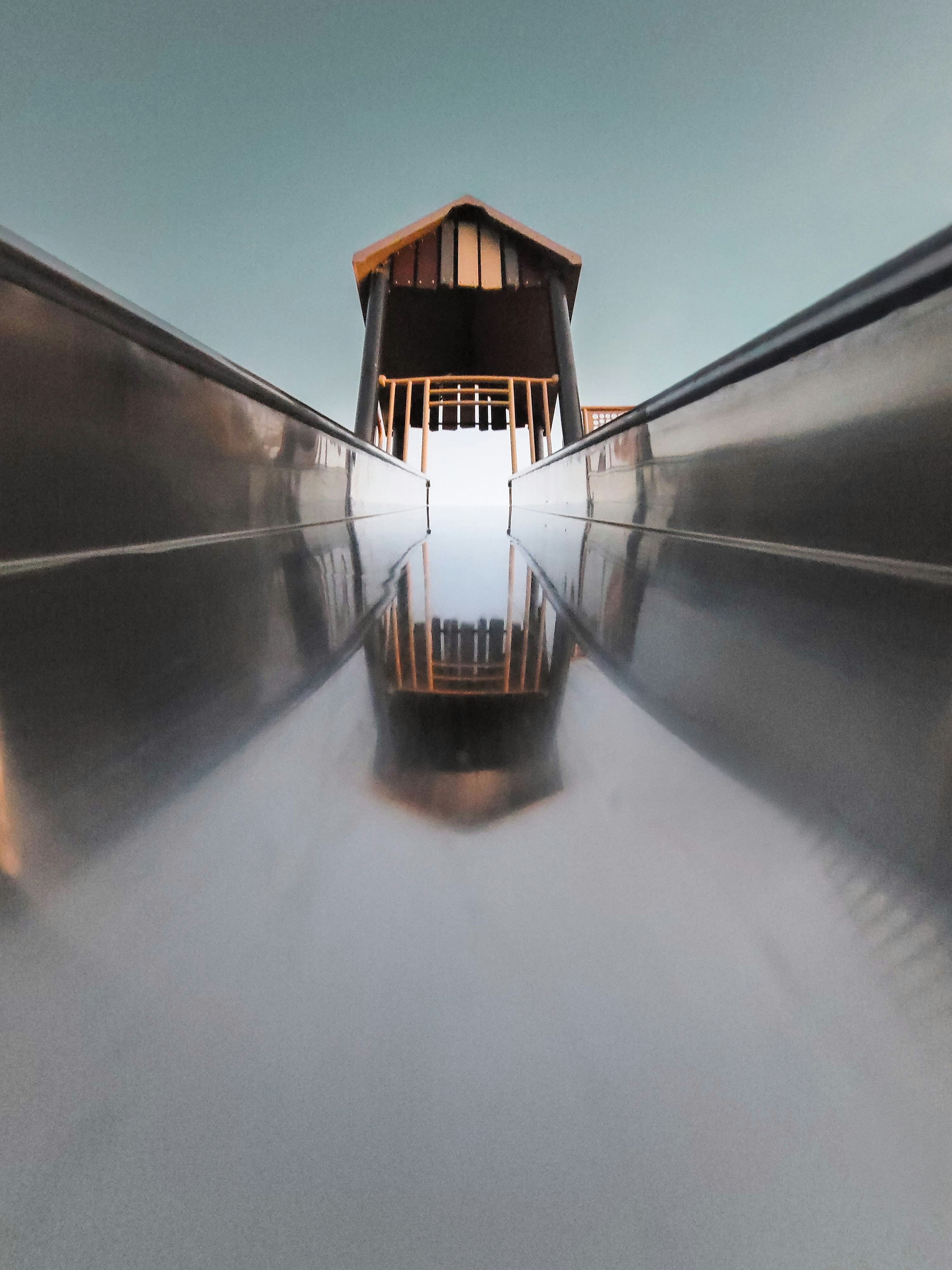 Eine Metallrutsche, die zu einer Holzkonstruktion führt.