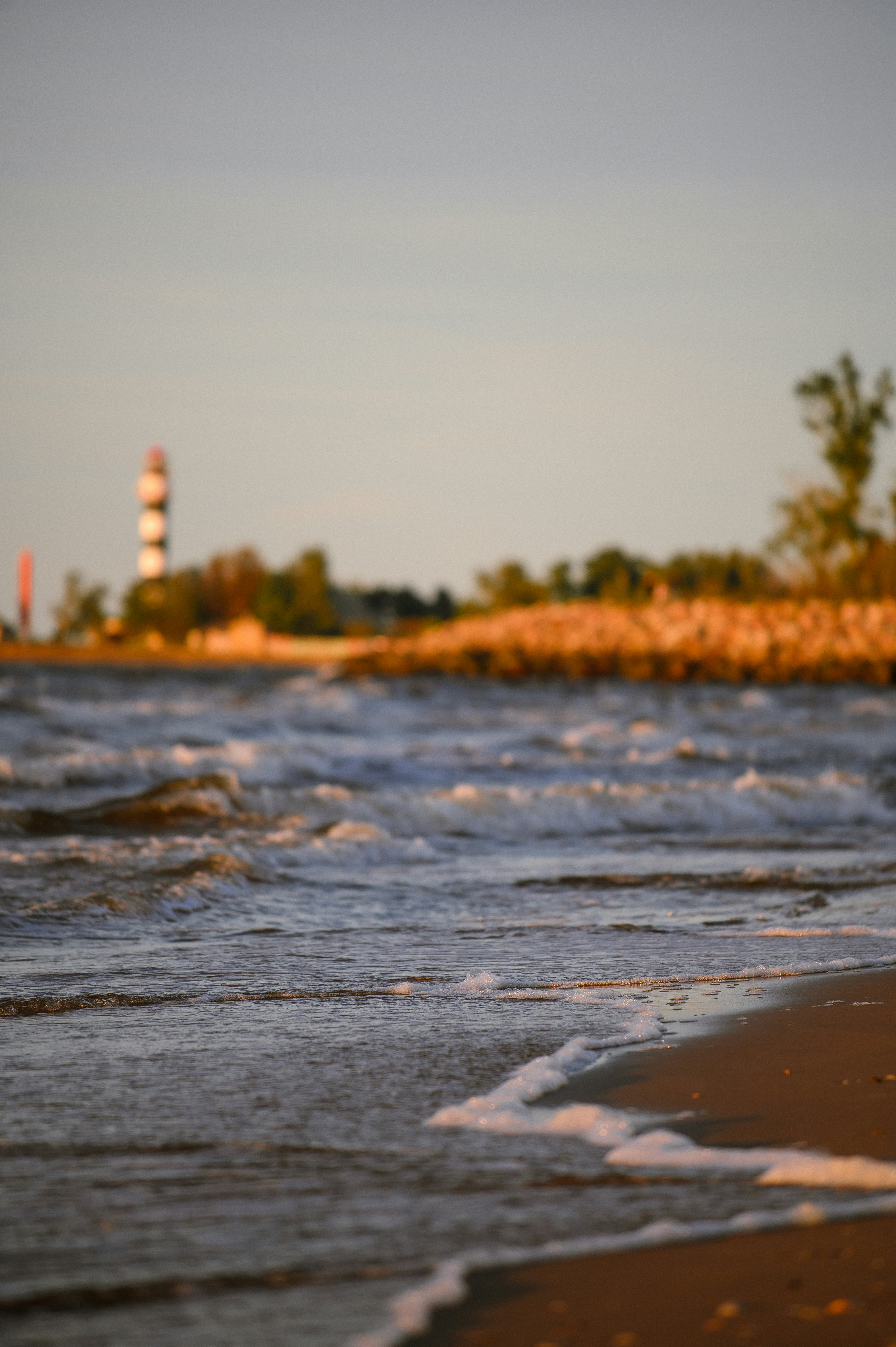 Lighthouse on a rocky shore with ocean waves