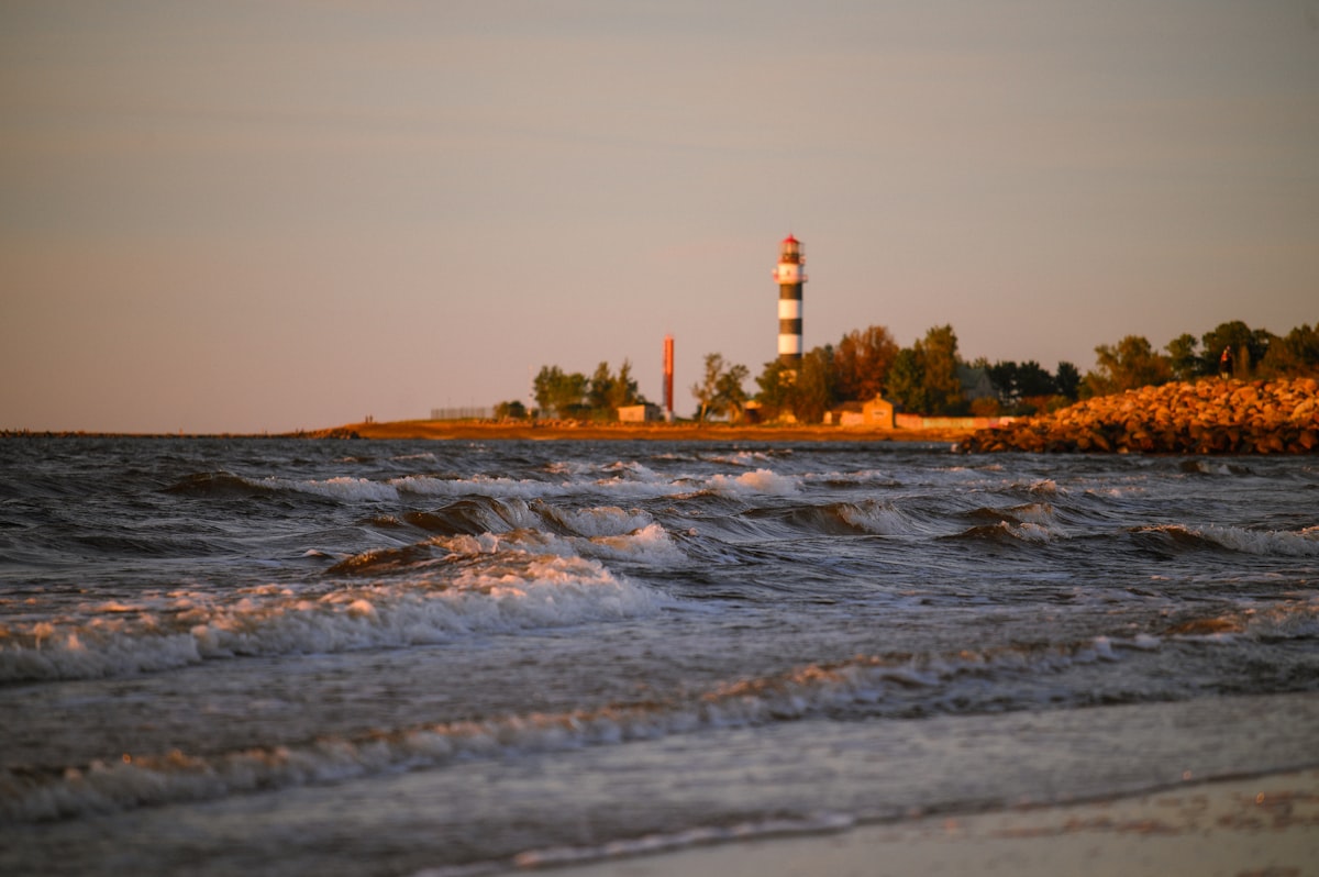 Lighthouse on a rocky shore at sunset