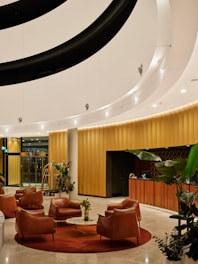 Modern hotel lobby with leather chairs and reception desk.