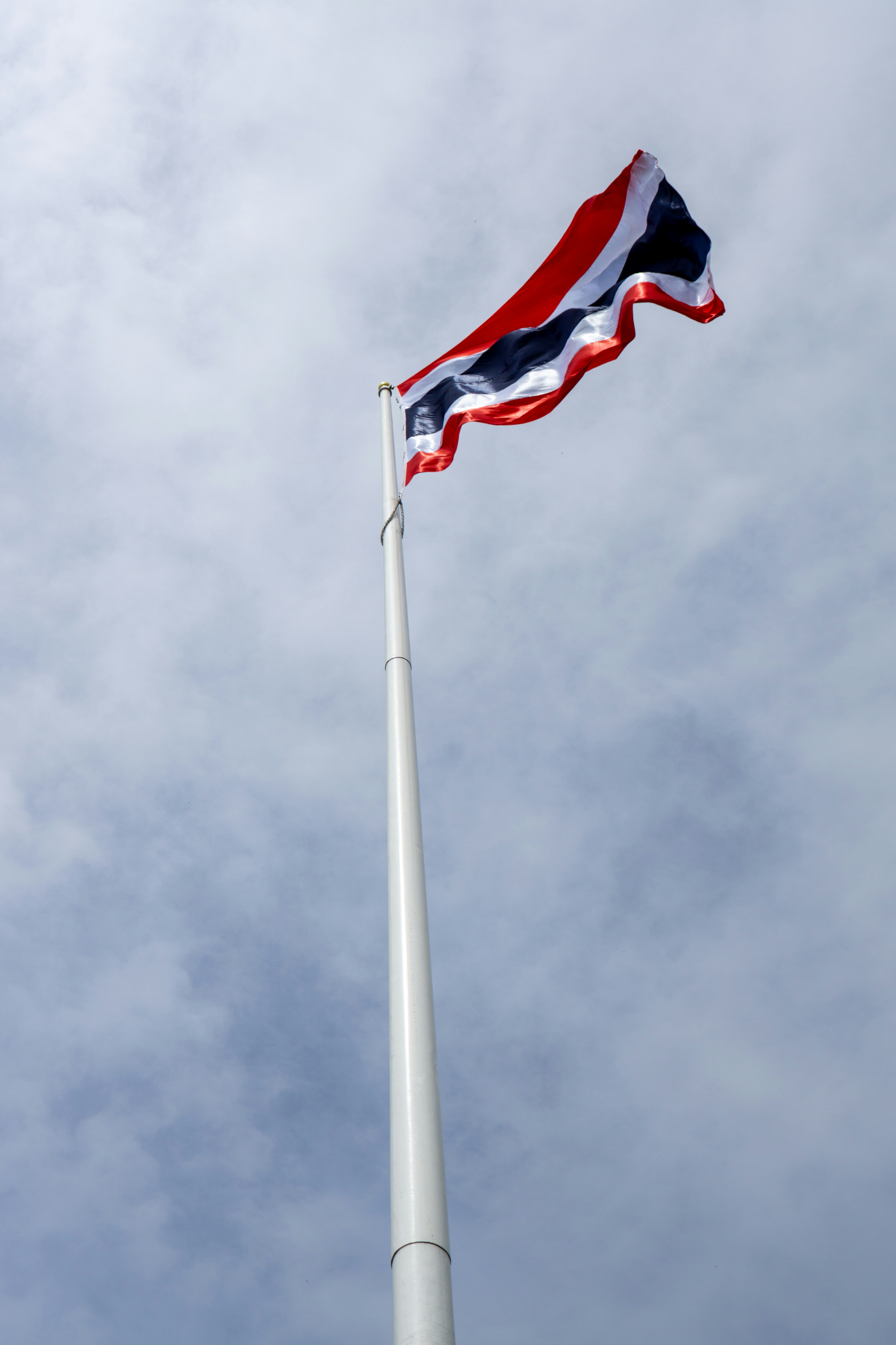 Flag of thailand waving against a cloudy sky