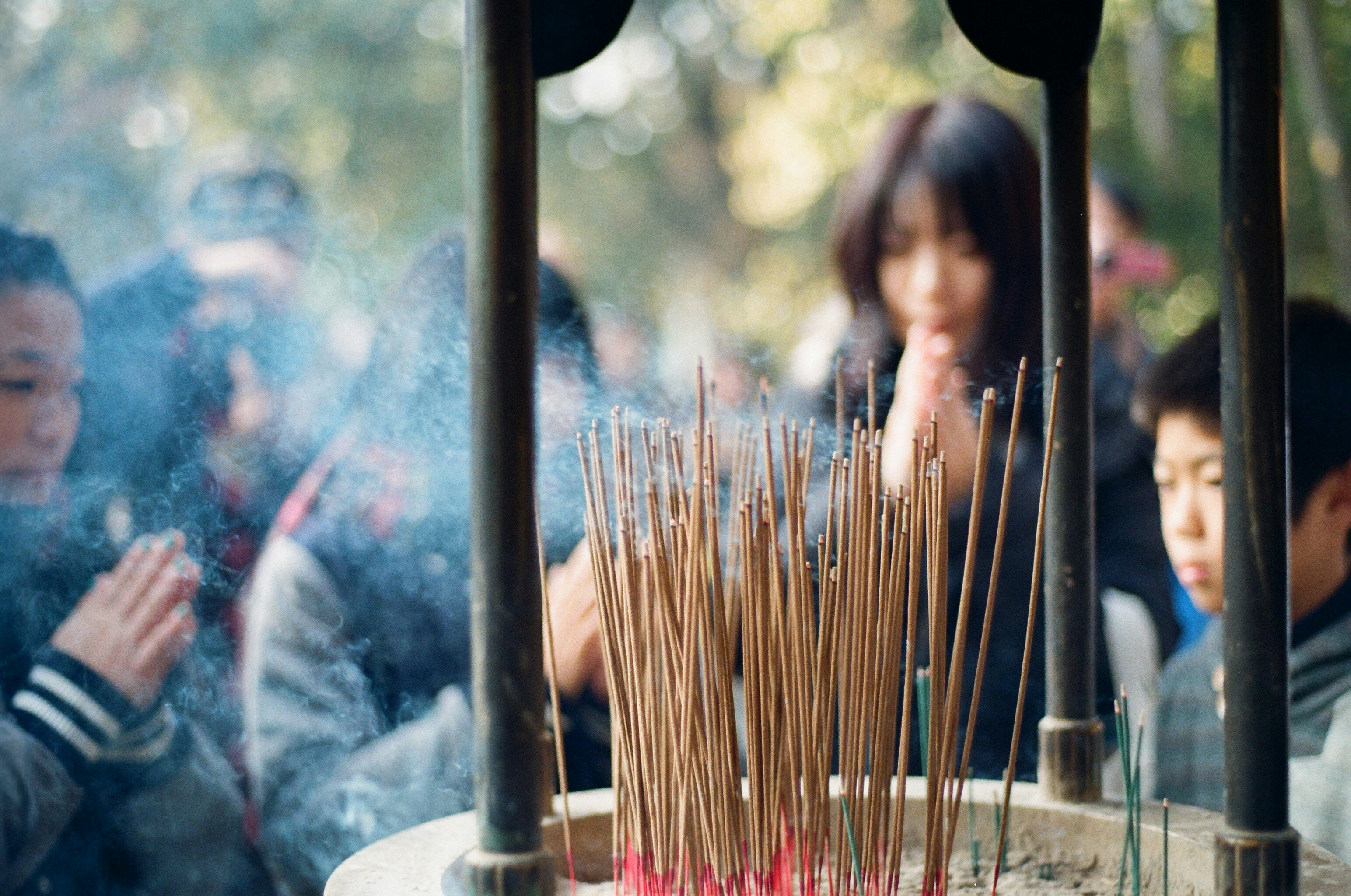 People praying with incense sticks burning