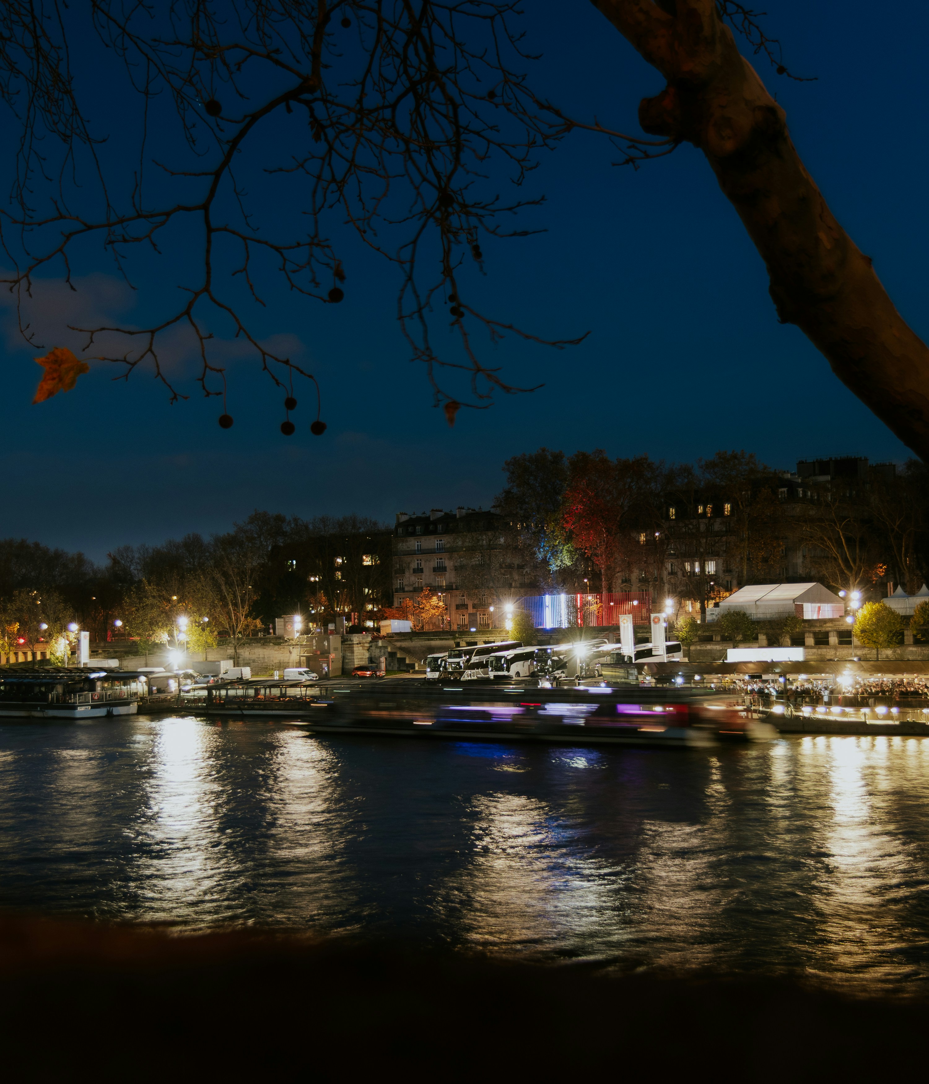 City lights reflect on a river at night.