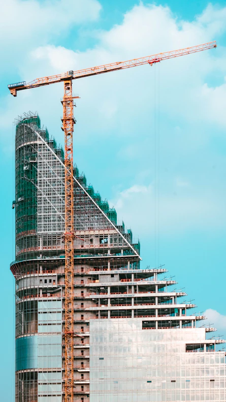 Construction crane next to a modern building under development.