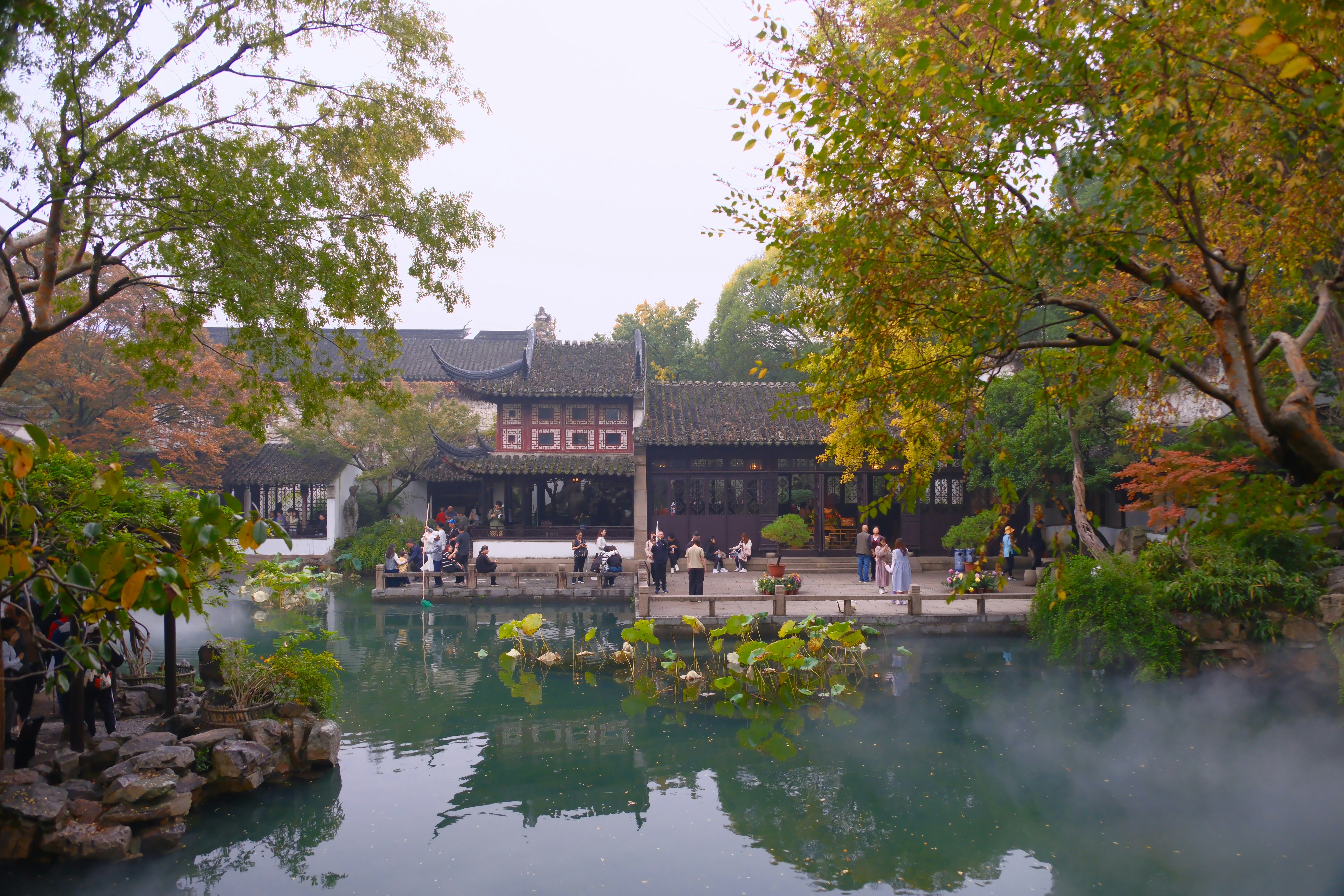 Traditional chinese garden with a pond and buildings.