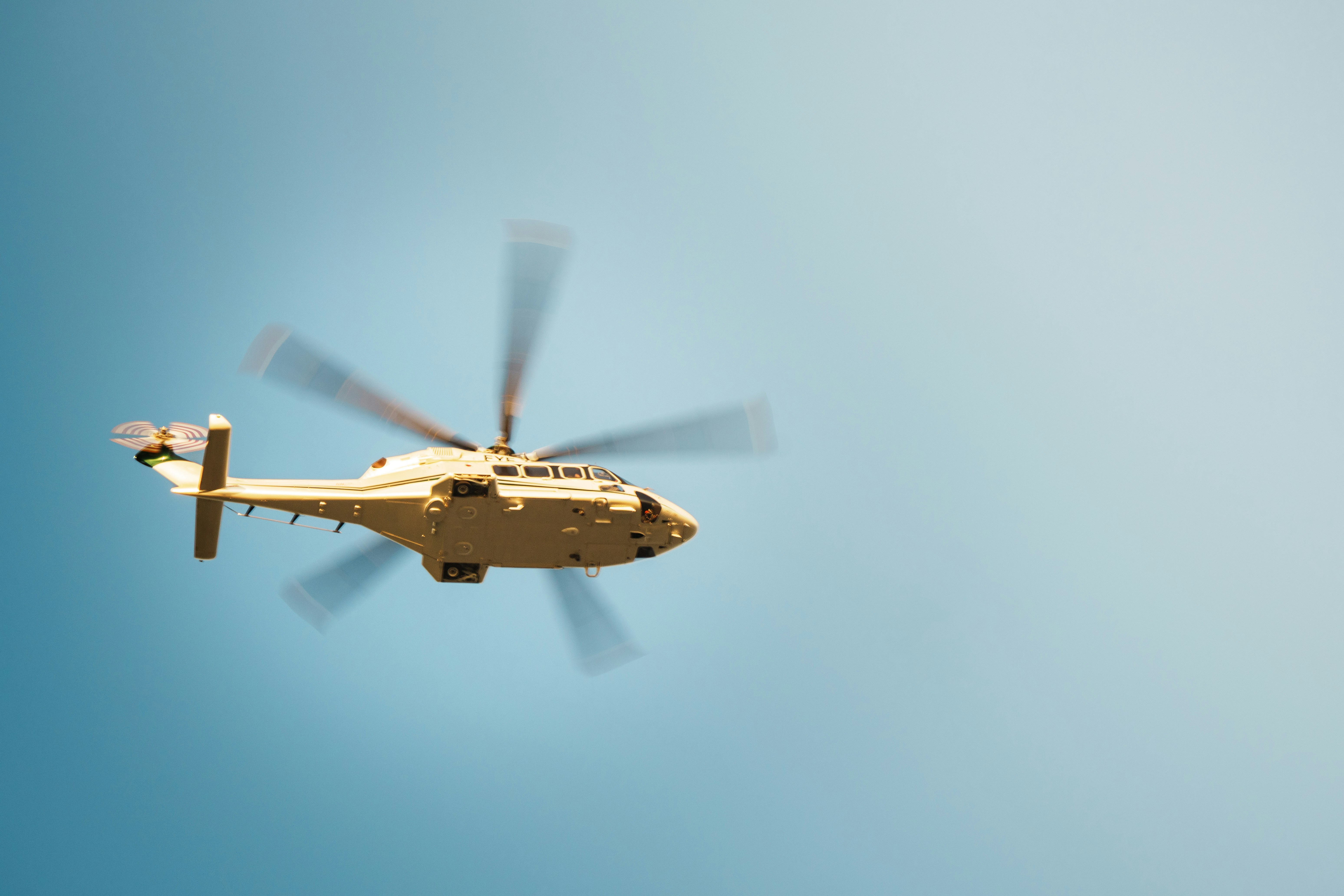 A helicopter flying in a clear blue sky.