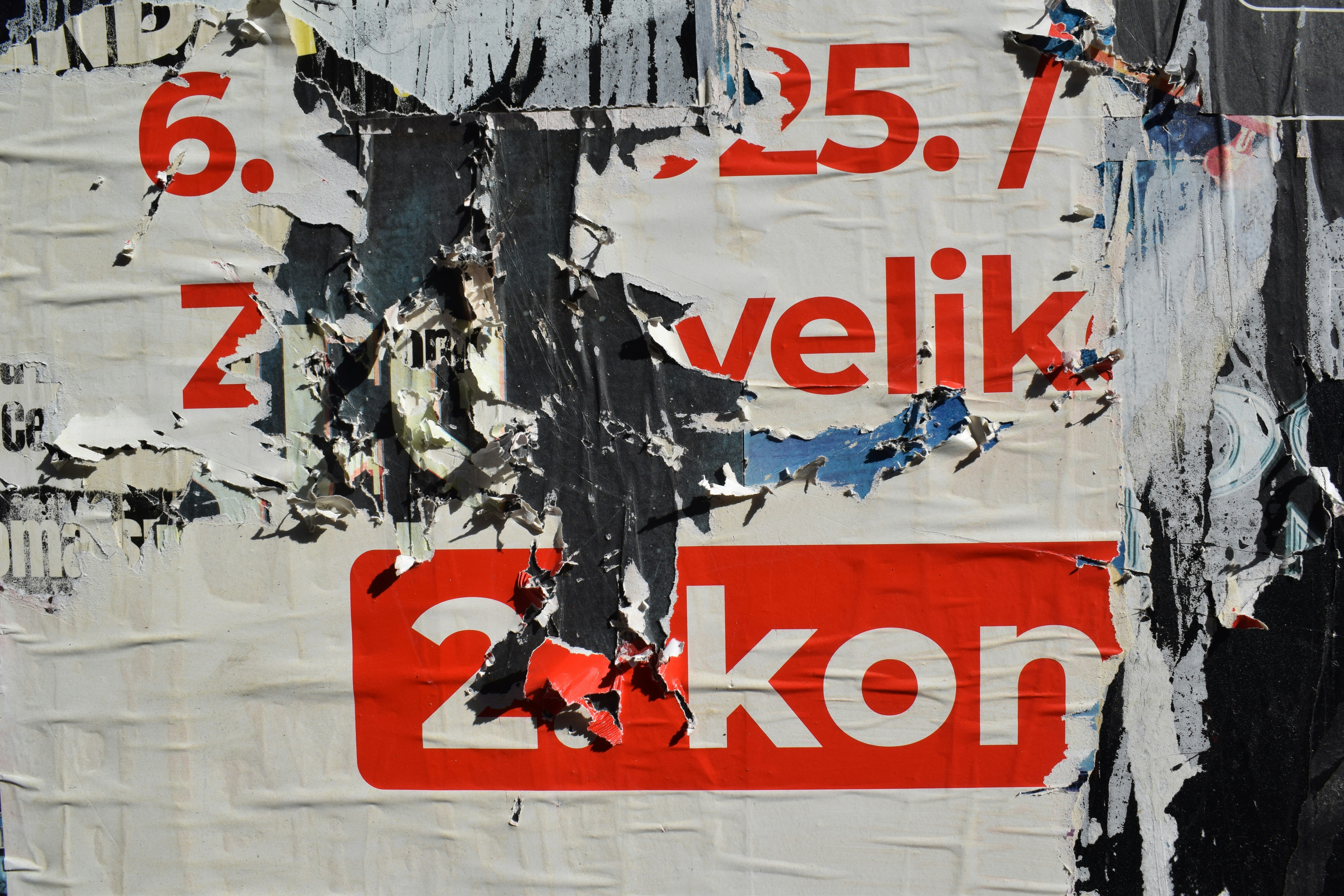Torn posters with red and white text.