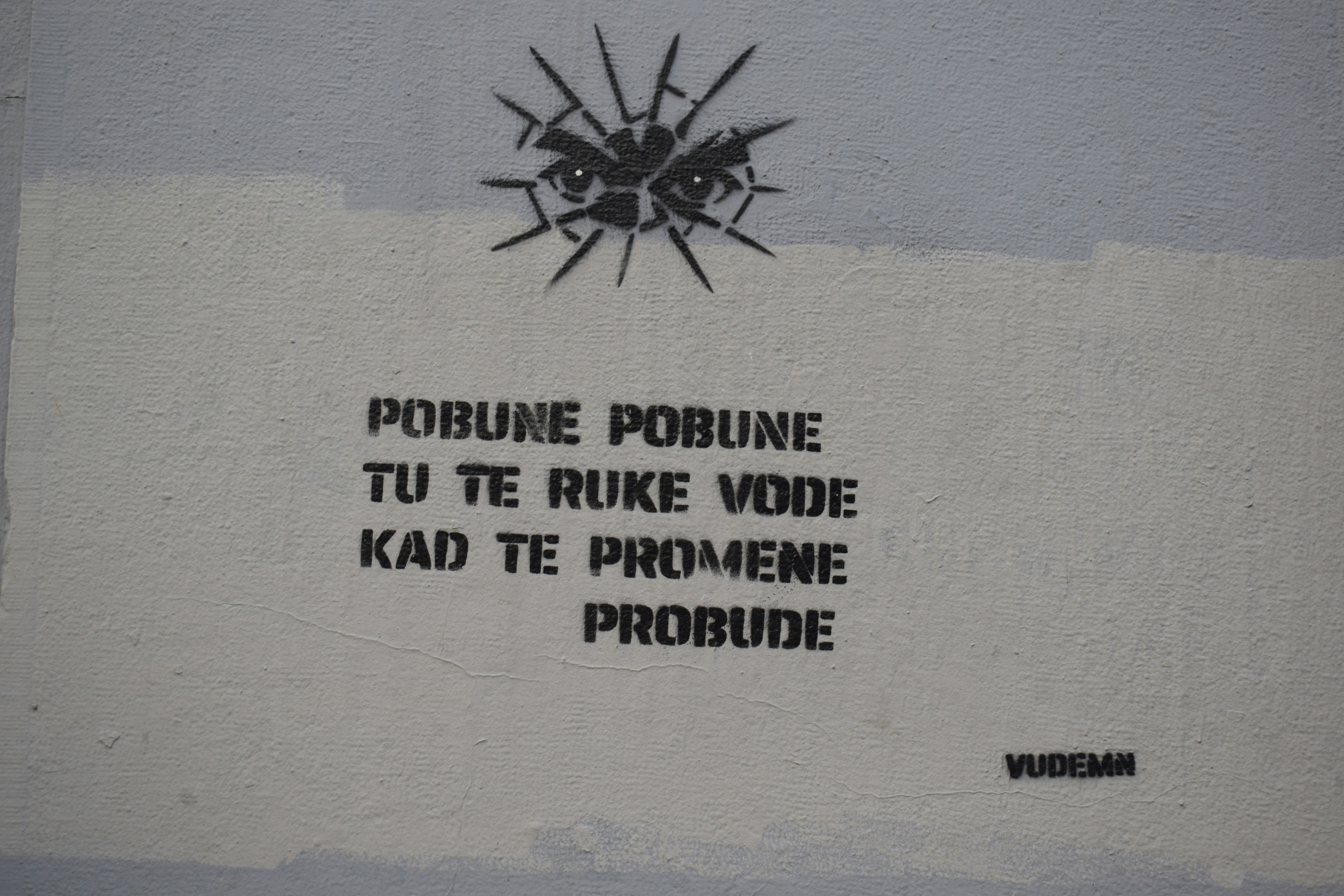 Graffiti with eyes and text on a wall