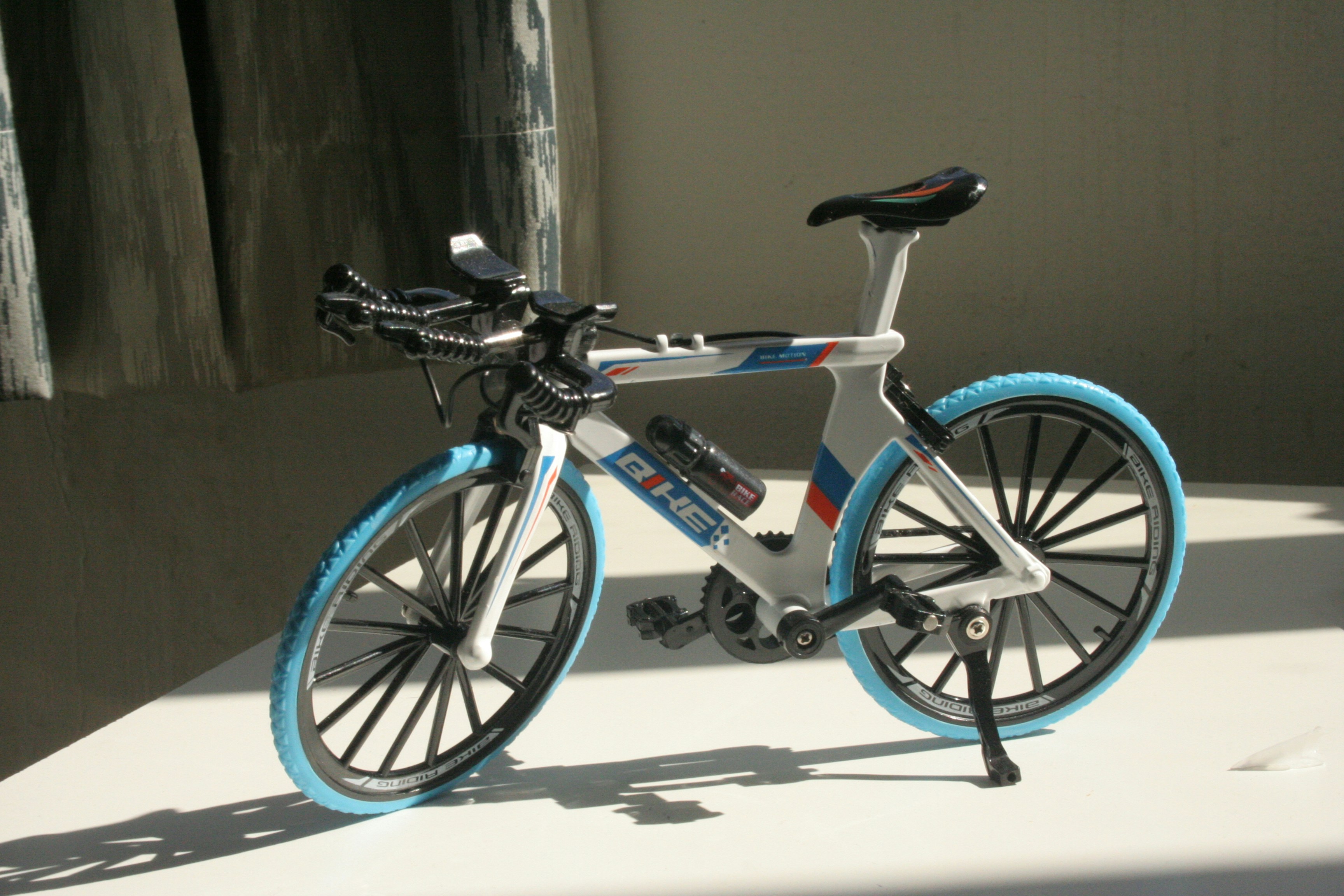 A miniature racing bicycle with blue tires.