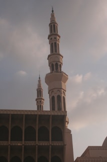 Two mosque minarets against a cloudy sky